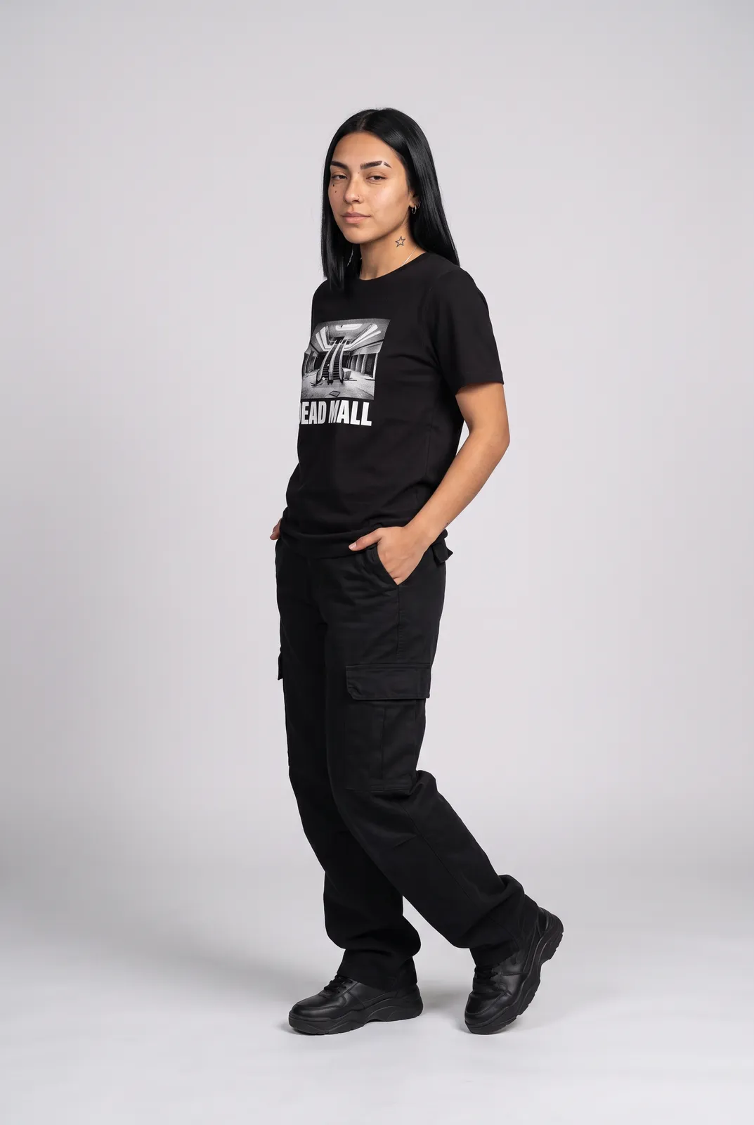 Nova Reyes wearing the DEAD MALL Tee in Black, three quarter lean