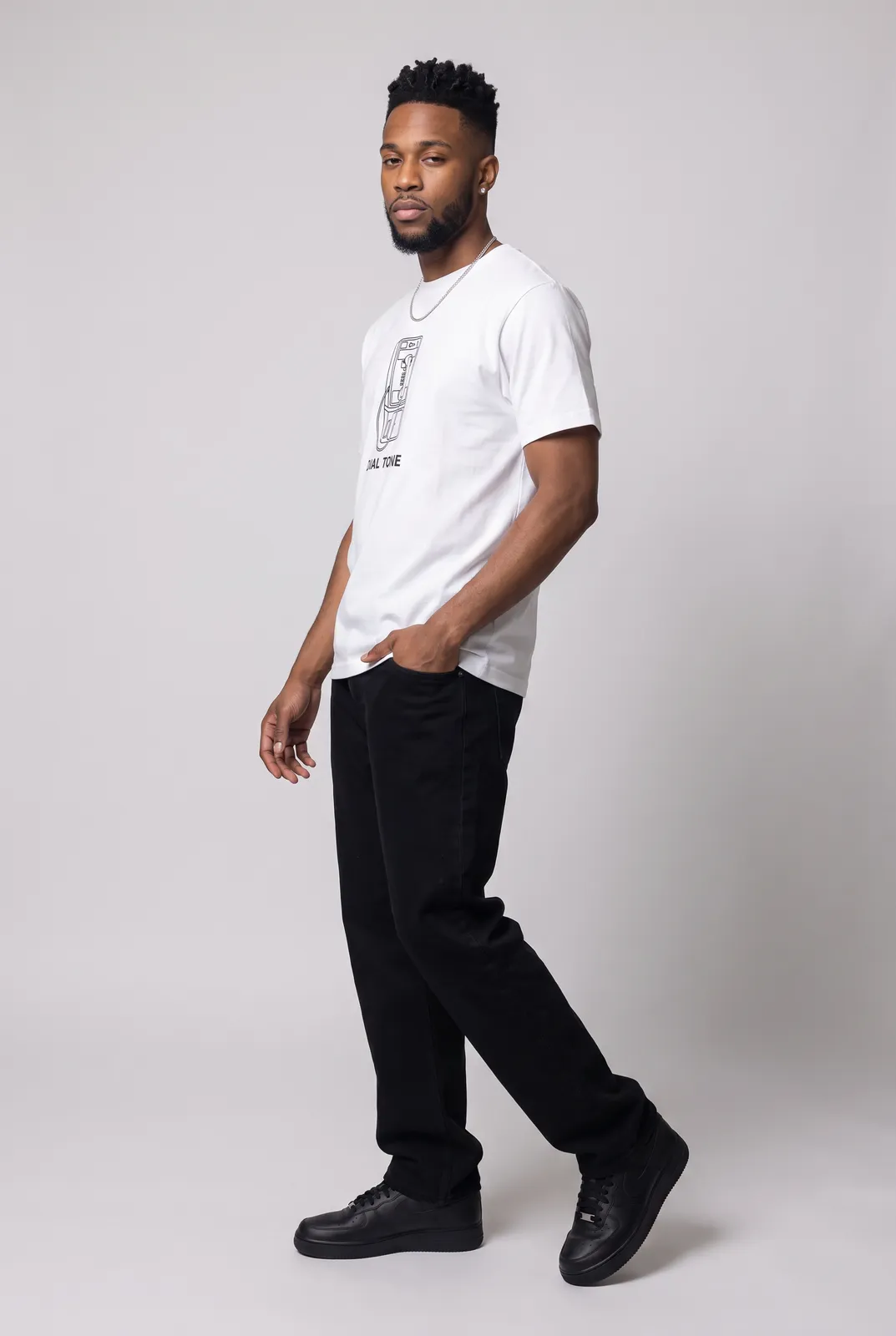Malik Carter wearing the DIAL TONE Tee in White, three quarter lean