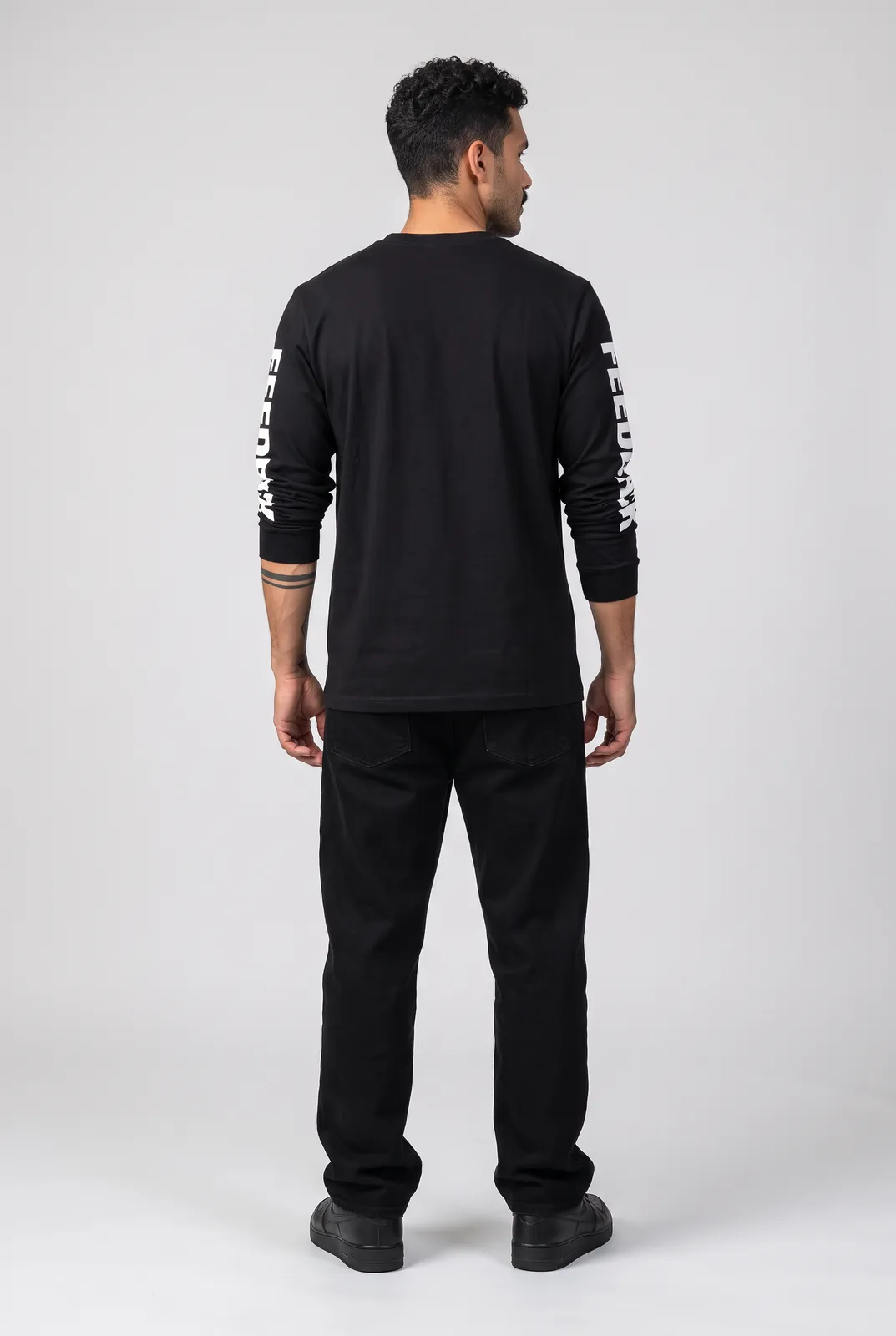 Diego Alvarez wearing the FEEDBACK Longsleeve in Black, back turn