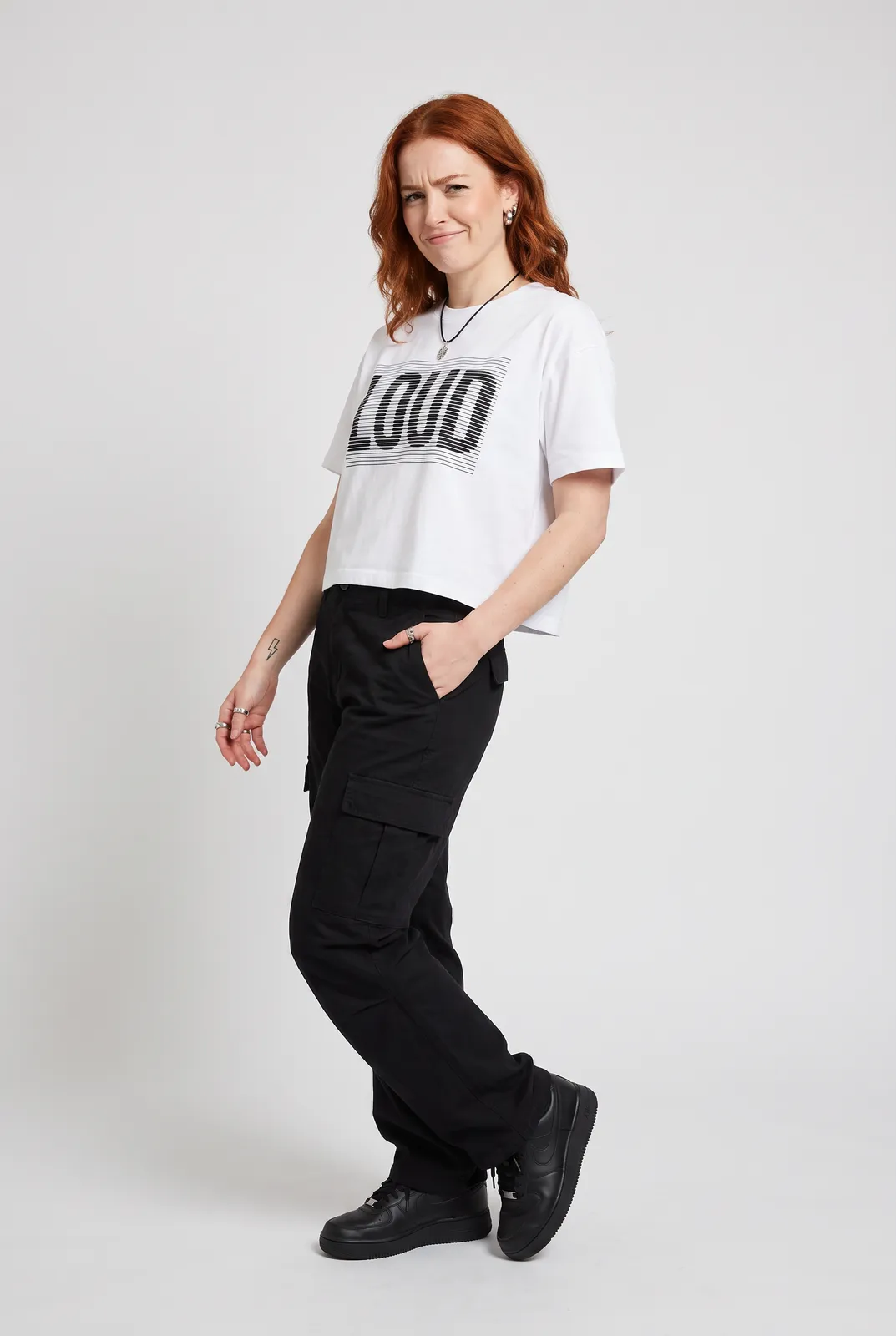 Maeve Gallagher wearing the LOUD Cropped Tee in White, three quarter lean