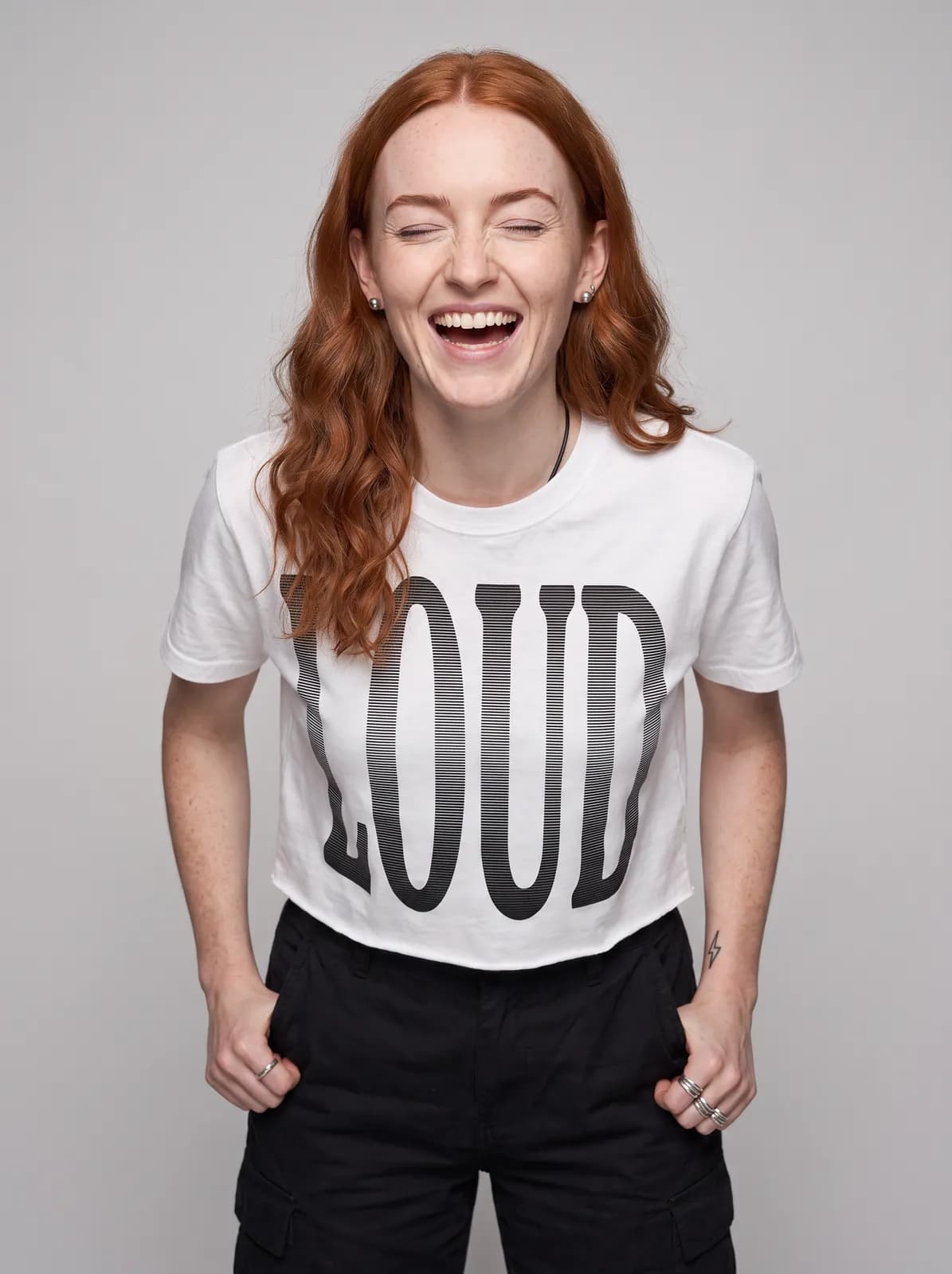 Maeve Gallagher wearing the LOUD Cropped Tee in White, waist up crop