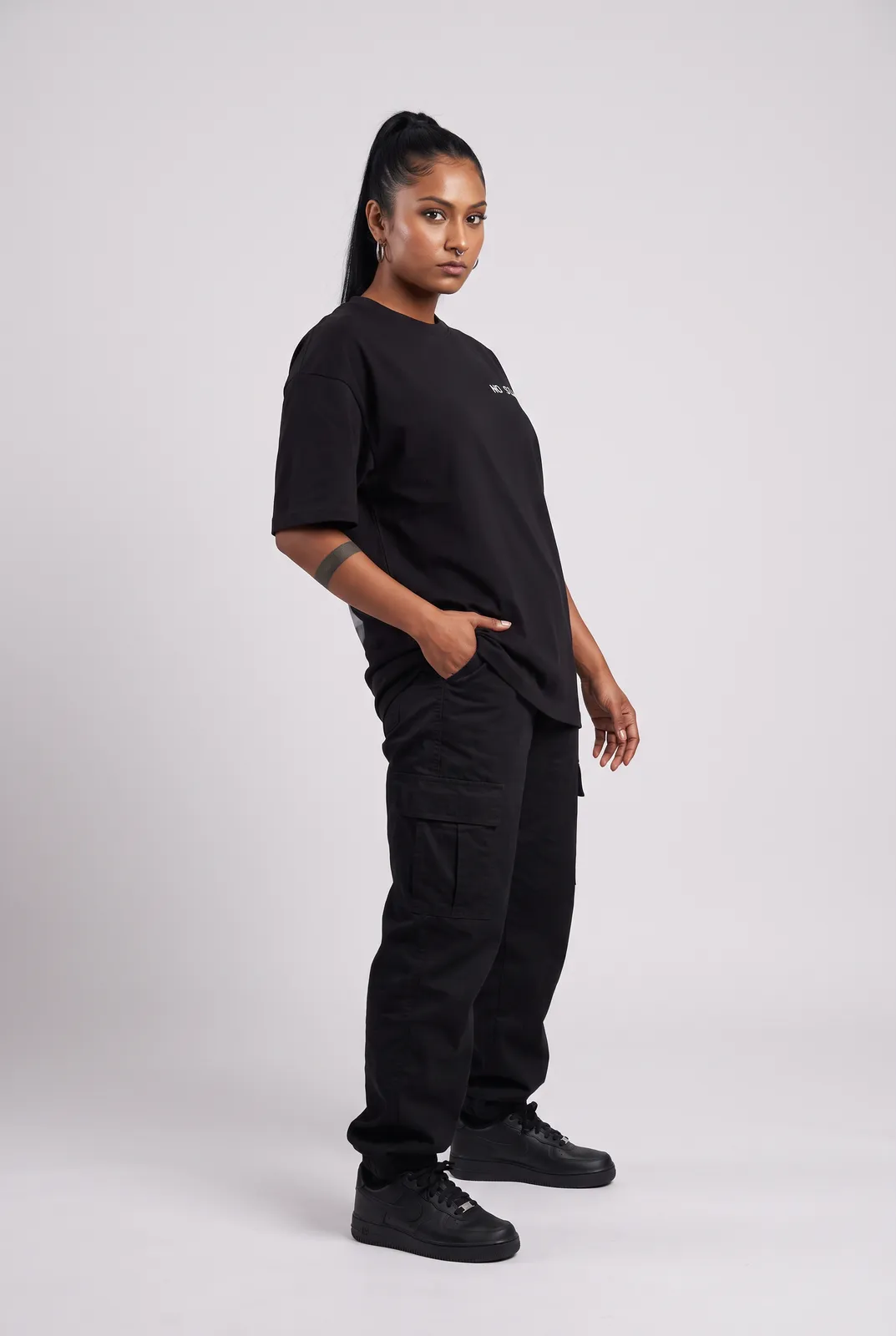 Zara Mehta wearing the NO SIGNAL Oversized in Black, three quarter lean