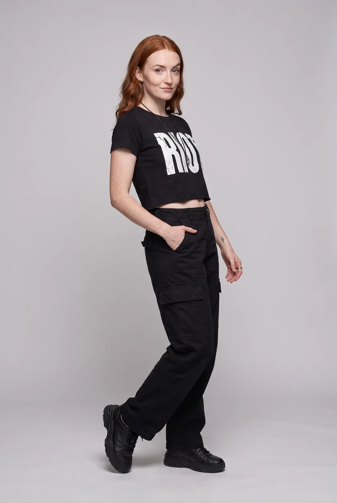 Maeve Gallagher wearing the RIOT Tee in Black, three quarter lean