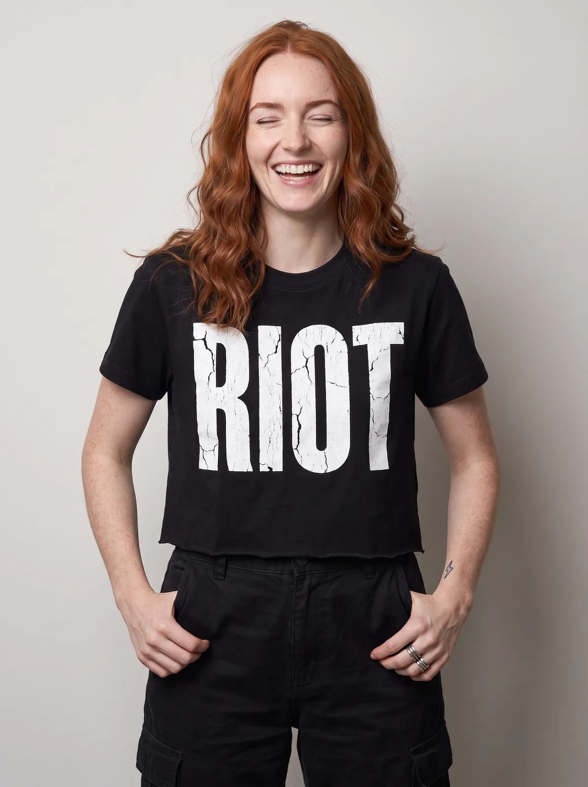 Maeve Gallagher wearing the RIOT Tee in Black, waist up crop