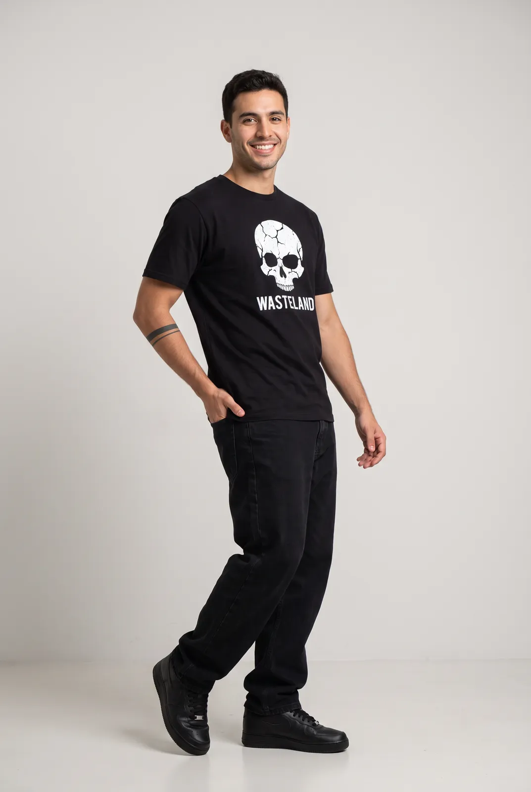 Diego Alvarez wearing the WASTELAND Tee in Black, three quarter lean