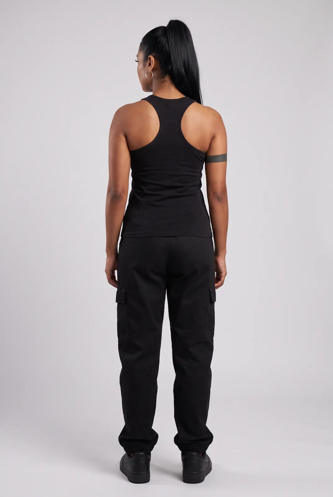 Zara Mehta wearing the WOLVES Tank in Black, back turn