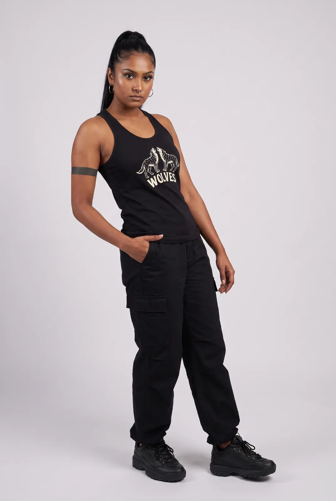 Zara Mehta wearing the WOLVES Tank in Black, three quarter lean